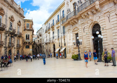 Siracusa, Sicilia, Italia - 10 Apr 2019: persone che camminano sulla Piazza Duomo nel centro storico. Il centro è situato sulla famosa isola di Ortigia. Popolare attrazione turistica. Foto Stock