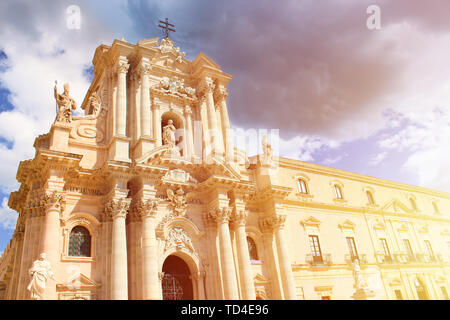 Bella Cattedrale cattolica romana di Siracusa in Sicilia, Italia presa dal basso in arancione la luce del tramonto. Il tempio fa parte del patrimonio mondiale dell'UNESCO. Architettura Barocca. Popolare meta turistica. Foto Stock