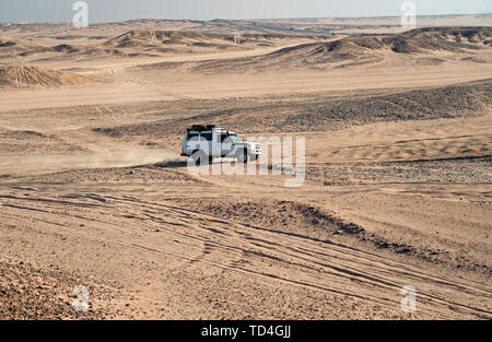 Gara di deserto di sabbia. Auto suv supera le dune di sabbia di ostacoli. Concorrenza racing sfida deserto. Unità auto offroad con nuvole di polvere. Offroad racing del veicolo con degli ostacoli nel deserto. Foto Stock