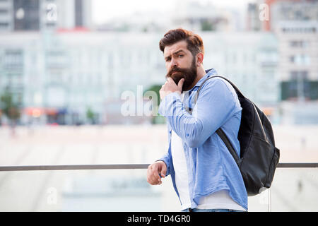 Tourist bello hipster con zaino stand street. Uomo con la barba e zaino esplorare la città. Viaggi e avventure del concetto. Turisti in vacanza. Hipster turista moderno background urbano. Foto Stock