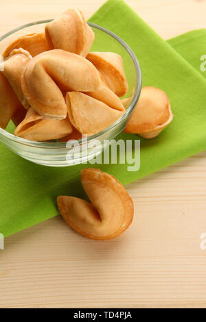 Fortune Cookie nel recipiente, sul tavolo di legno Foto Stock