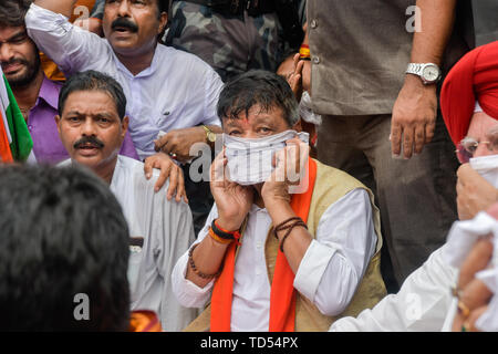 Kolkata, India. 12 Giugno, 2019. Kolkata, India. 12 Giugno, 2019. Kailash Vijayvargiya nazionale segretario generale del BJP si copre il viso per proteggersi dal gas lacrimogeni fumo come essi prendono parte durante la protesta in Kolkata. Bharatiya Janata Party lavoratori protestare contro le uccisioni del BJP i lavoratori e anche per aver evidenziato il presunto degrado della legge e dell'ordine nello stato, la polizia ha usato idranti e gas lacrimogeni gusci verso i manifestanti che hanno tenuto un raduno a Kolkata questura. Credito: SOPA Immagini limitata/Alamy Live News Foto Stock