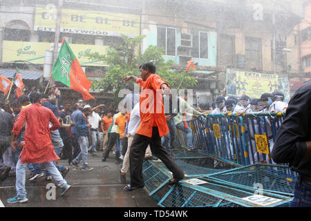 Kolkata, India. 12 Giugno, 2019. Gli ufficiali di polizia fuoco acqua canonici verso il manifestante durante la dimostrazione. Il leader del BJP ha annunciato una marcia di protesta verso Laalbazar, quartier generale della Polizia del Bengala Occidentale dopo tre dei suoi lavoratori sono stati uccisi in atti di violenza in Sandeshkhali in Nord 24 distretto Parganas la scorsa settimana. La loro marcia di protesta a Kolkata quartier generale della polizia nella città di area Lalbazar è diventata violenta il mercoledì come il Partito dei lavoratori si sono scontrati con la polizia. Credito: SOPA Immagini limitata/Alamy Live News Foto Stock