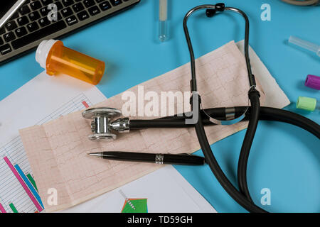 Uno stetoscopio con cardiograms sulla tastiera del computer le statistiche mediche Foto Stock