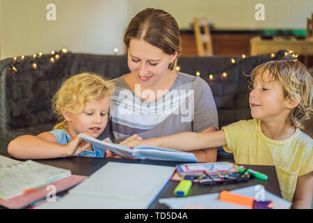 Docente e tutor per la scuola un ragazzo e una ragazza al tavolo. O figlia della madre e figlio. Homeschooling Foto Stock