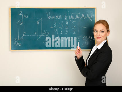 Ritratto di donna insegnante vicino a lavagna in aula Foto Stock