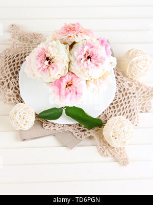 Le Rose in coppa su tovaglioli su sfondo di legno Foto Stock