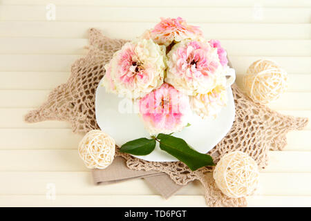 Le Rose in coppa su tovaglioli su sfondo di legno Foto Stock