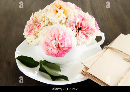 Le Rose in coppa su tovaglioli su sfondo di legno Foto Stock