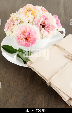 Le Rose in coppa su tovaglioli su sfondo di legno Foto Stock
