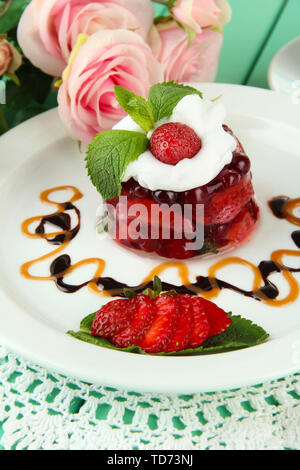 Gelatina di gustosi dessert con frutti di bosco freschi, il Rosa Rose sfondo Foto Stock