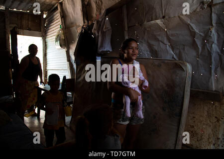 Caracas, Venezuela. 8 Giugno, 2019. Petare è la più grande baraccopoli di Caracas Venezuela, e il terzo più grande in America Latiin. Qui una ragazza di 14 anni tiene i suoi 3 settimana di età bambino in camera 2 home in Petare. Ella vive in questa casa con 10 altri membri della famiglia. Credito: Allison cena/ZUMA filo/Alamy Live News Foto Stock