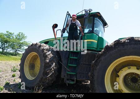 Missouri, USA. Decimo Giugno, 2019. Blake Hurst, presidente del Missouri Farm Bureau, anche un mais e soia agricoltore Tarkio, Northwest Missouri, discende dal suo trattore sul Suo terreno coltivato in Tarkio, Missouri, Stati Uniti, 10 giugno 2019. Per andare con funzione: gli agricoltori del Midwest devastato da inondazioni storiche, USA-Cina le tensioni commerciali Credito: Liu Jie/Xinhua/Alamy Live News Foto Stock