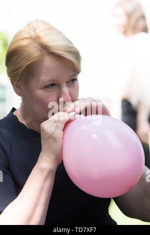 Dresden, Germania. Xiii Giugno, 2019. Famiglia federale Ministro Franziska Giffey (SPD) si gonfia un palloncino in 'Eckstein' asilo nido. Lo stesso giorno, Giffey firmato a 269 milioni di euro contratto per migliorare la qualità dei centri di assistenza diurna in Baviera tra il 2019 e 2022. Credito: Sebastian Kahnert/dpa-Zentralbild/dpa/Alamy Live News Foto Stock