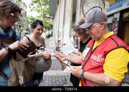 Athens, Athens, Grecia. 12 Giugno, 2019. Michael, 72, uno dei Shedia di venditori ambulanti, vende copie di Shedia durante il tour ufficiale.Il tour di ''˜invisibile di Atene è organizzato da Shedia e va in pezzi di Atene che i locali ritengono di essere pericolose aree della città e sono generalmente evitati dai turisti. Shedia è il solo greco street giornale. Il tour prevede che mostra le condizioni dei senzatetto in Atene. Il Ministero greco della solidarietà sociale stima che vi sono stati più di 1.500 senzatetto per le strade di Atene nel 2018. (Credito Immagine: © Lexie Harrison-Cri Foto Stock