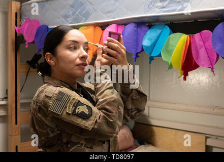 Bagram, Afghanistan. 30 ott 2018. Un soldato di sesso femminile si prepara per il giorno come lei si mette il trucco nella sua piccola quarti viventi mentre ella visite Bagram. Loro sono di gran lunga più servizi presso altre basi fuori Dahlke. FOB(forward base operativa) Dahlke è un nuovo austero US Army base, a partire dalla primavera del 2018, in Afghanistan che ha iniziato con una grande presenza di soldati dal 101st combattere la Brigata Aerea. Dahlke è strategicamente situato a circa 60 miglia a sud di Kabul. Ogni tipo di supporto aereo missione è fatto da qui, da medevac provvedere al rifornimento a combattere. Dahlke fu costruito dal suolo fino oltre il Foto Stock