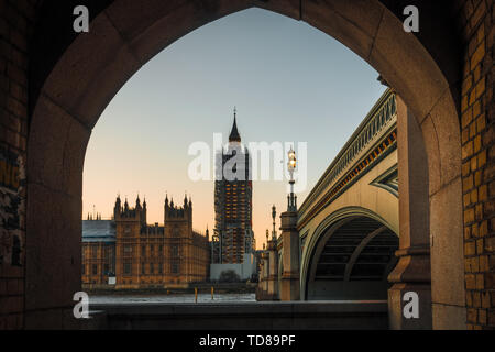 Big ben incorniciata da un muro di pietra, foto scattata al blue ora. In questo momento il Big Ben è stato in costruzione. Foto Stock