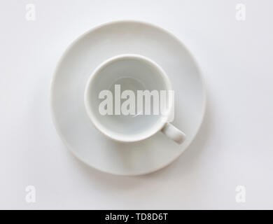 Svuotare tazza da caffè con piattino su sfondo bianco. Vista dall'alto. Chiudere l'immagine. Foto Stock