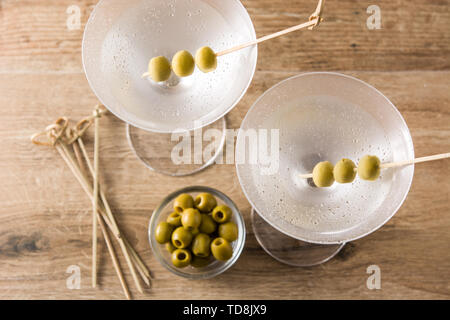 Classic Martini Dry con olive sul tavolo di legno e lo sfondo grigio Foto Stock