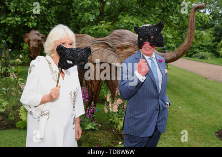 La duchessa di Cornovaglia e il Principe di Galles tenere maschere viso come essi un'accoglienza per la famiglia elefante sfera animale al Clarence House, Londra. Foto Stock