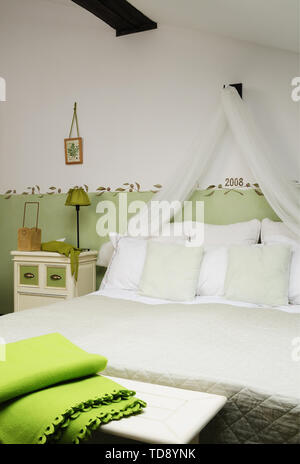 Verde coperta ripiegata sul bancone di comodo letto matrimoniale con cuscini e tendina in mansarda camera da letto NEL REGNO UNITO E IN IRLANDA I DIRITTI SOLTANTO Foto Stock
