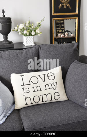 Tela Bianca stampata cuscino - Amore è in casa mia - sul grigio scuro divano UK & IRISH UTILIZZARE SOLO Foto Stock