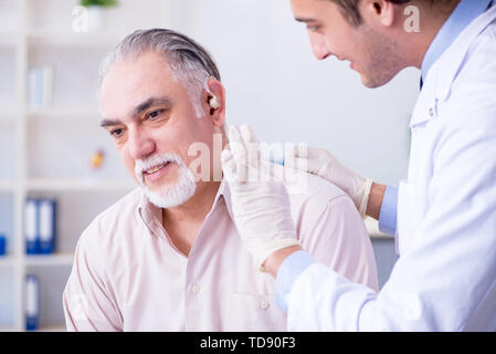 Paziente di sesso maschile con problema di udito visita medico otorhinolaryngologist Foto Stock