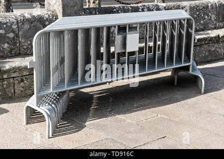 Molti mobili di recinzioni metalliche impilate sulla pubblica piazza con pavimentazione in pietra. Zona di restrizione concept Foto Stock