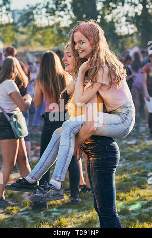 Ritratto di sorridenti giovani ragazze con vernici colorate su facce e vestiti. Due amici di trascorrere del tempo sulla Holi festival a colori Foto Stock