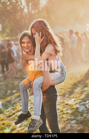 Ritratto di sorridenti giovani ragazze con vernici colorate su facce e vestiti. Due amici di trascorrere del tempo sulla Holi festival a colori Foto Stock