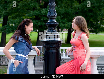 Ritratto di due belle giovani donne in parco e parlare con sorrisi felici. Amici donne attraenti di successo che chiacchierano nel parco Foto Stock