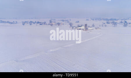 Una veduta aerea di un mattino nevoso in terreni agricoli Amish Foto Stock