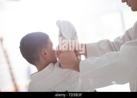 Bloccato a mano. Dai capelli scuri boy avente la sua mano bloccato mentre si pratica aikido con trainer Foto Stock