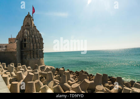 Lone tempio indù con bandiera sul mare Arabico costa con interruttori di onda Foto Stock