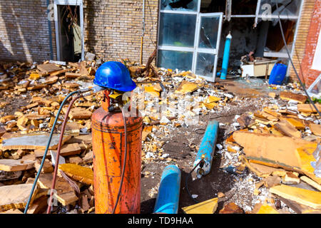 Il gas usato attrezzatura di saldatura per il taglio di metallo di scarto, cilindri con Propano e azoto, guanti e casco blu, torcia di acetilene. Foto Stock