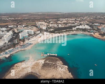 Cipro splendida costa e mare mediterraneo di colore turchese. Case sulla costa mediterranea. Città turistica. Spiaggia di Nissi. La vacanza estiva in mare Foto Stock