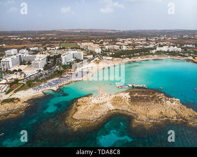 Cipro splendida costa e mare mediterraneo di colore turchese. Case sulla costa mediterranea. Città turistica. Spiaggia di Nissi. La vacanza estiva in mare Foto Stock