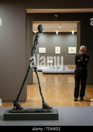 Vancouver, Canada. Xiii Giugno, 2019. Un visitatore guarda la scultura "uomo a piedi' durante l'anteprima media del "Alberto Giacometti : una linea attraverso il tempo' mostra alla Galleria d'Arte di Vancouver a Vancouver, Canada, 13 giugno 2019. La mostra che è in programma dal 16 giugno al 7 settembre 29, presenta opere tra dipinti, sculture, disegni e litografie creato dall'artista svizzero Alberto Giacometti e i suoi contemporanei. Credito: Liang Sen/Xinhua/Alamy Live News Foto Stock