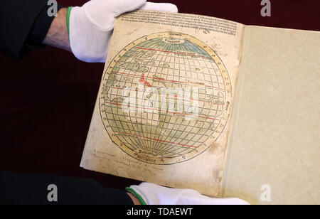 Rostock, Germania. Xiii Giugno, 2019. Robert Zepf, direttore mostra presso la Biblioteca universitaria La prima edizione in folio di Mundus Novus di Amerigo Vespucci dal 1505, stampata da Rostock del segretario del consiglio di Hermann Barckhusen (c. 1460-1528/29), con un full-page dipinte a mano e illustrazione di una mappa del mondo dopo l'antico geografo Claudio Tolomeo. La straordinaria nuova acquisizione della Biblioteca universitaria sarà presentato ufficialmente il 14.06.2019. Credito: Bernd Wüstneck/dpa-Zentralbild/dpa/Alamy Live News Foto Stock