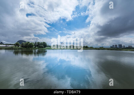 Lakeside costruzione spazio verde traliccio sotto le nuvole Foto Stock