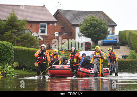 I residenti sono adottate per la sicurezza in un gommone dai soccorsi in Wainfleet Tutti i Santi, in Lincolnshire, dove le strade e le proprietà sono inondati dopo la città aveva più di due mesi di pioggia in soli due giorni. Il Royal Air Force è stato elaborato dopo il fiume di macerazione violato le sue rive. Foto Stock