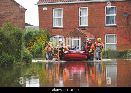 I residenti sono adottate per la sicurezza in un gommone dai soccorsi in Wainfleet Tutti i Santi, in Lincolnshire, dove le strade e le proprietà sono inondati dopo la città aveva più di due mesi di pioggia in soli due giorni. Il Royal Air Force è stato elaborato dopo il fiume di macerazione violato le sue rive. Foto Stock