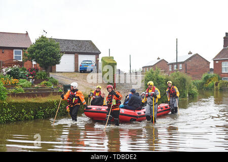 I residenti sono adottate per la sicurezza in un gommone dai soccorsi in Wainfleet Tutti i Santi, in Lincolnshire, dove le strade e le proprietà sono inondati dopo la città aveva più di due mesi di pioggia in soli due giorni. Il Royal Air Force è stato elaborato dopo il fiume di macerazione violato le sue rive. Foto Stock