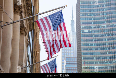 USA il simbolo nel New York strade. Bandiera americana su un edificio del centro di Manhattan, blur Empire State building e scyscrapers sullo sfondo Foto Stock