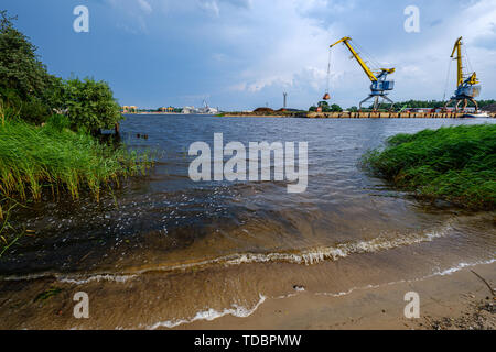 Nuvole temporalesche formando su Riga spedizione cargo porta sul fiume Daugava il 13 giugno 2019. Riga, Lettonia Foto Stock