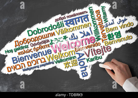 Benvenuti in molte lingue diverse word cloud su lavagna Foto Stock