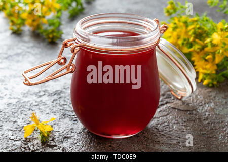 Un vasetto di olio rosso costituito da erba di San Giovanni Fiori Foto Stock