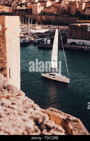 Barca a vela su un fiume a Marsiglia, Francia con incredibile architettura sullo sfondo Foto Stock