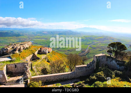 Mura del Castello di Lombardia in ENNA, SICILIA. L'era normanna fortificazione con vista sul bel paesaggio di campagna e montagne adiacenti. In silhouette sullo sfondo del monte Etna. Foto Stock