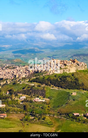 Storico villaggio arabo Calascibetta sulla sommità delle colline in Sicilia, Italia. Prese con vicine montagne e verde paesaggio. Fotografato da Enna. Era normanna fortezza. Foto Stock